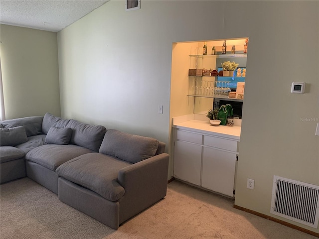 living room featuring vaulted ceiling, light carpet, and a textured ceiling