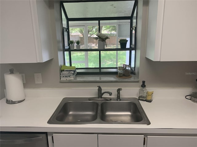 kitchen with dishwasher, sink, and white cabinetry