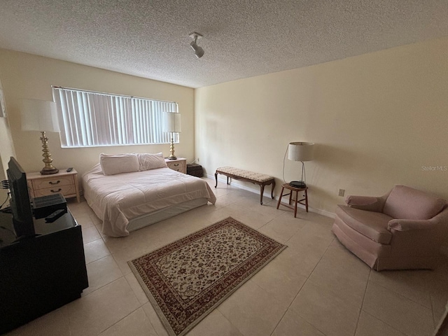 bedroom with light tile patterned flooring and a textured ceiling