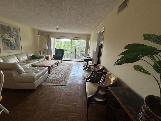 living room with dark parquet flooring and a textured ceiling