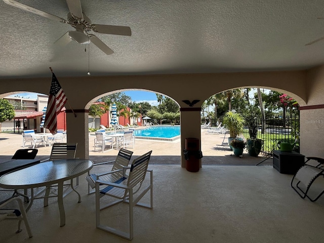 view of patio with ceiling fan and a community pool