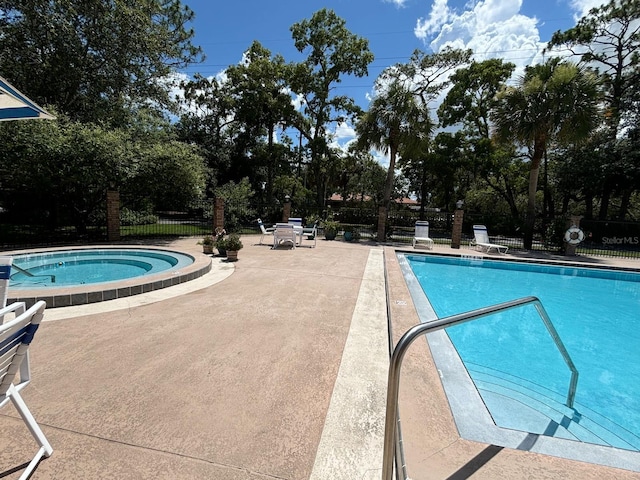 view of pool with a community hot tub and a patio