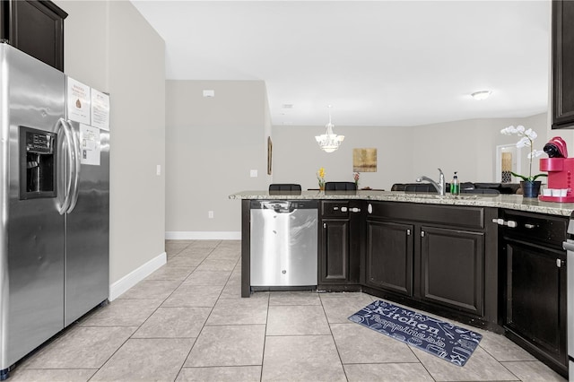 kitchen featuring sink, light tile patterned floors, light stone counters, kitchen peninsula, and stainless steel refrigerator with ice dispenser