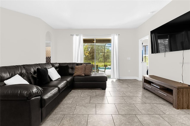 living room featuring light tile patterned floors and vaulted ceiling