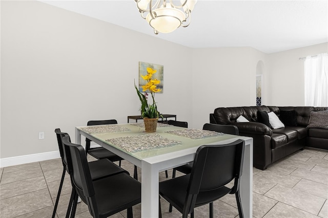 tiled dining room with a chandelier