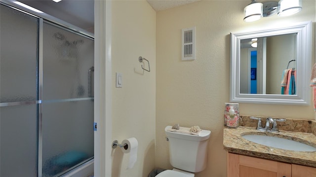 bathroom with vanity, toilet, and a shower with door