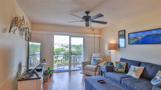 living room featuring hardwood / wood-style floors, a textured ceiling, and ceiling fan