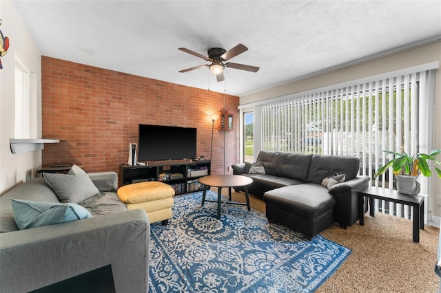 living room with ceiling fan, carpet floors, and brick wall