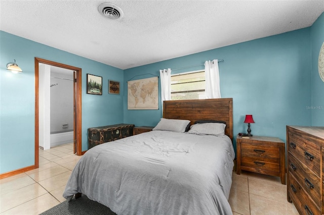 bedroom featuring light tile patterned floors, a textured ceiling, and connected bathroom