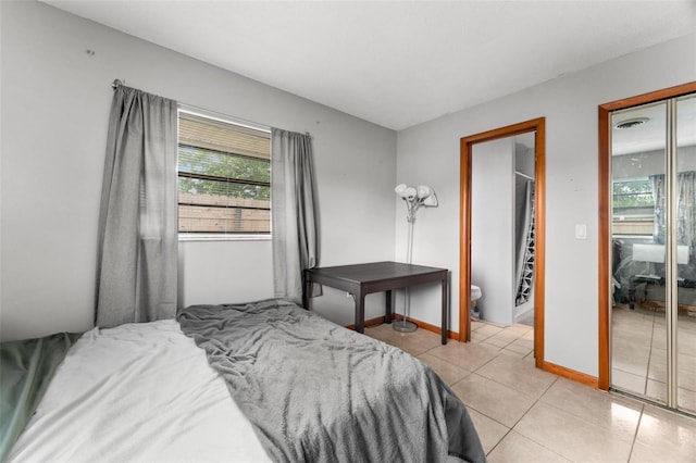 tiled bedroom featuring connected bathroom