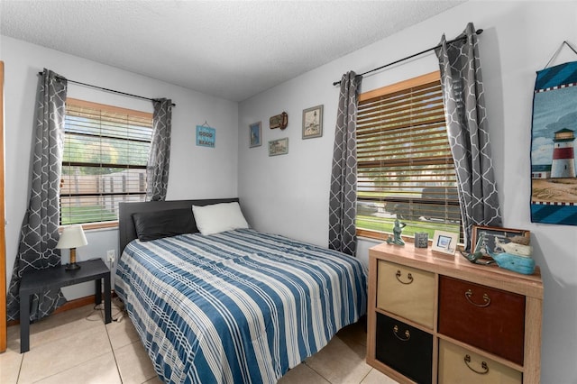 bedroom featuring a textured ceiling and light tile patterned flooring