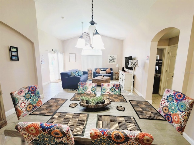 tiled dining room with vaulted ceiling and an inviting chandelier