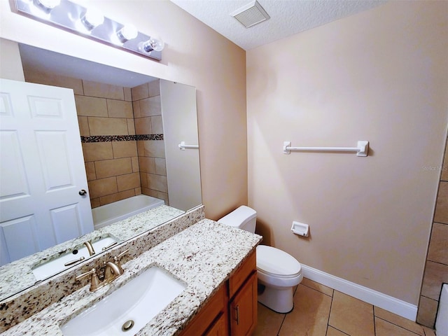 bathroom featuring toilet, a textured ceiling, tile patterned floors, and vanity