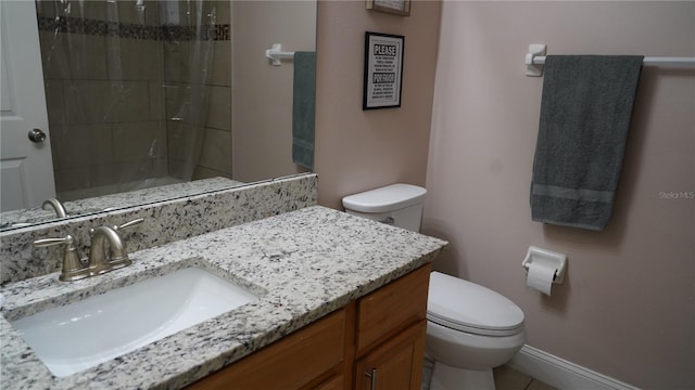 bathroom featuring toilet, vanity, and walk in shower