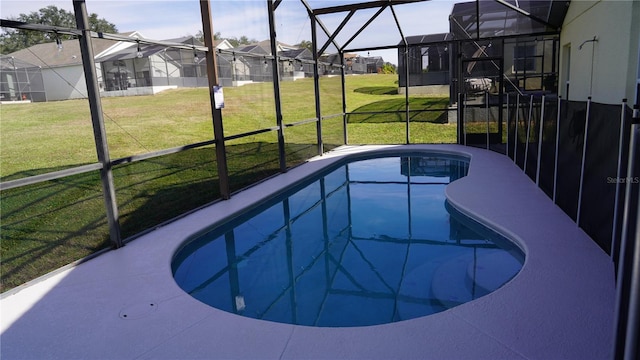 view of pool with a lawn and a lanai