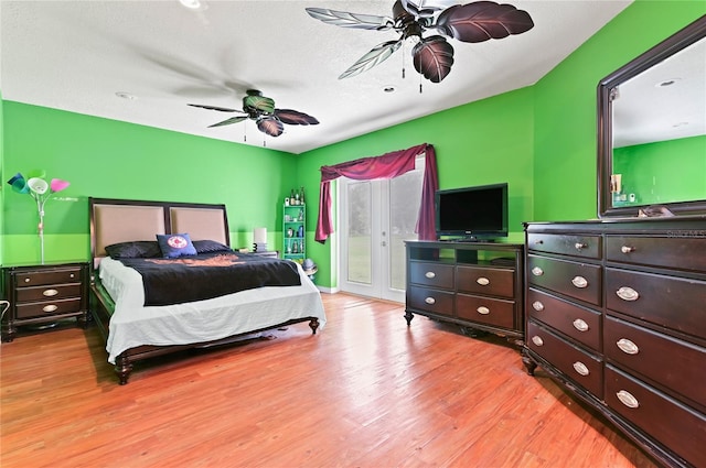 bedroom featuring ceiling fan, a textured ceiling, access to outside, and wood-type flooring