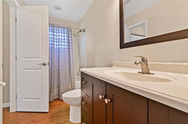 bathroom featuring hardwood / wood-style flooring, toilet, and vanity with extensive cabinet space