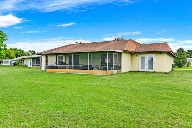 rear view of house featuring a sunroom and a yard