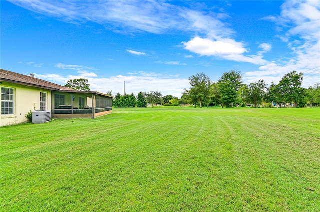 view of yard with a sunroom and central air condition unit