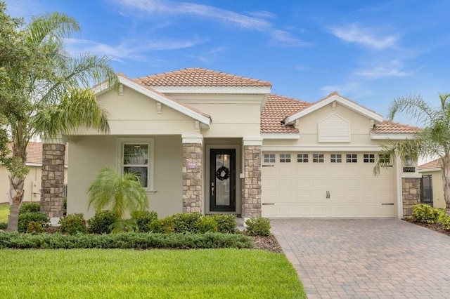 mediterranean / spanish home featuring a garage and a front lawn