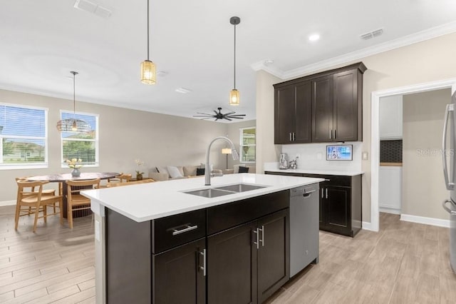 kitchen featuring sink, crown molding, dishwasher, pendant lighting, and a kitchen island with sink