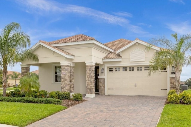 mediterranean / spanish-style home featuring cooling unit, a front yard, and a garage