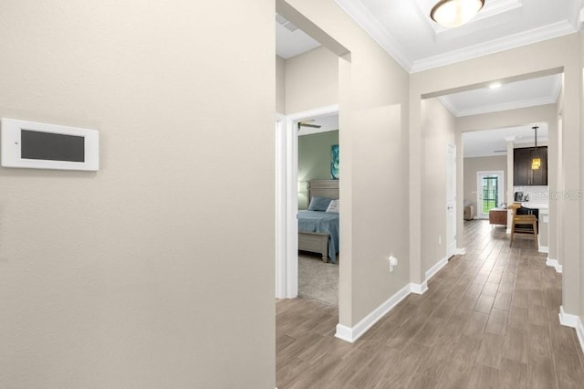 hallway with hardwood / wood-style floors and ornamental molding