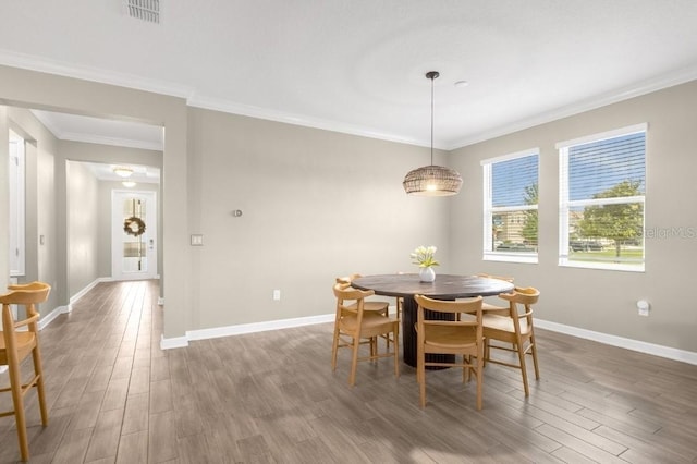 dining space featuring dark hardwood / wood-style floors and ornamental molding