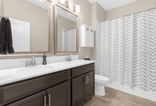 full bathroom featuring shower / bath combo, vanity, and toilet