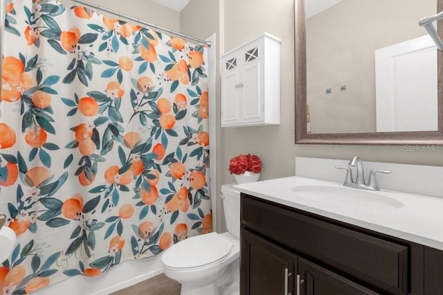 bathroom with hardwood / wood-style floors, vanity, and toilet