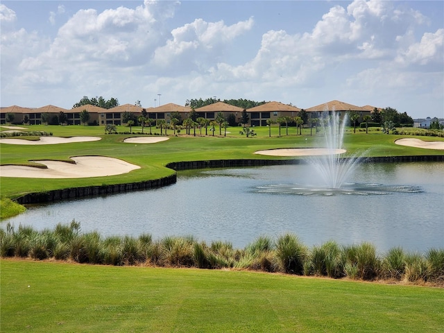 view of property's community with a yard and a water view