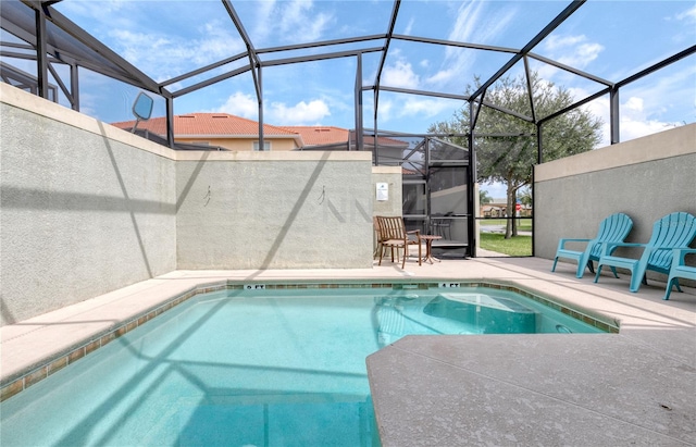 view of pool with a patio and glass enclosure