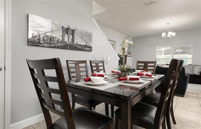 dining room with a notable chandelier and light tile floors