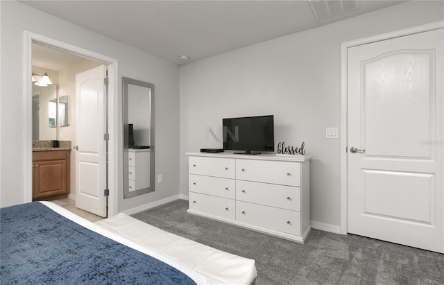 bedroom with baseboards, ensuite bathroom, carpet flooring, and visible vents