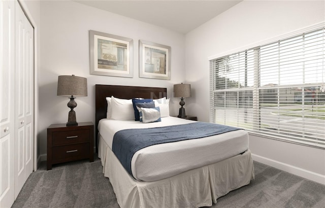 carpeted bedroom featuring a closet and baseboards