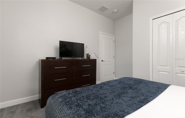 carpeted bedroom with a closet, baseboards, and visible vents