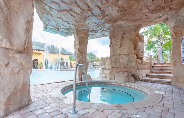 pool with stairway and a community hot tub