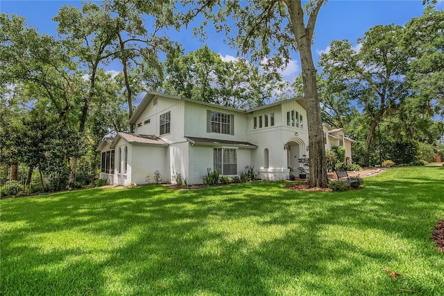 rear view of property with a sunroom and a lawn