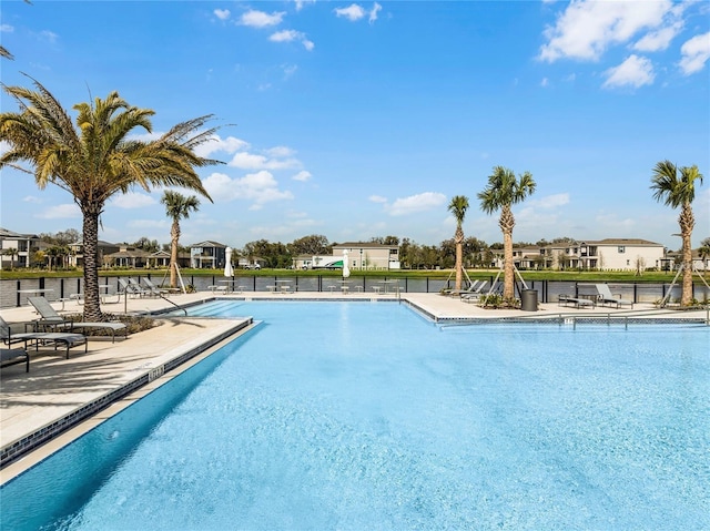 community pool with a residential view, a patio, and fence