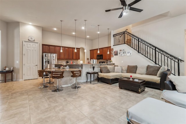 tiled living room featuring a towering ceiling and ceiling fan