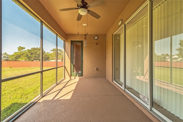 unfurnished sunroom with ceiling fan