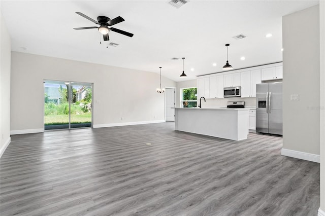 unfurnished living room featuring lofted ceiling, ceiling fan, wood-type flooring, and sink