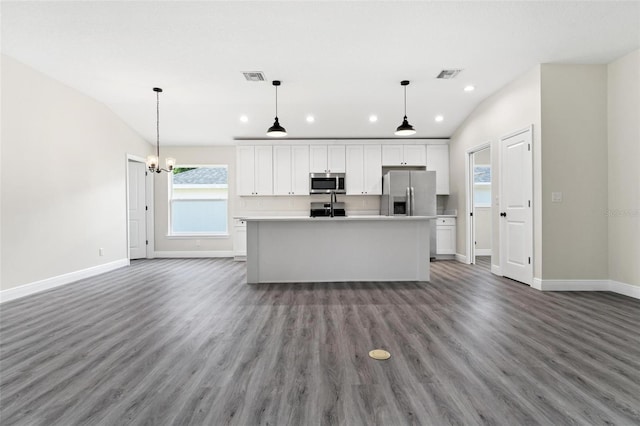 kitchen featuring white cabinets, a kitchen island with sink, vaulted ceiling, and appliances with stainless steel finishes