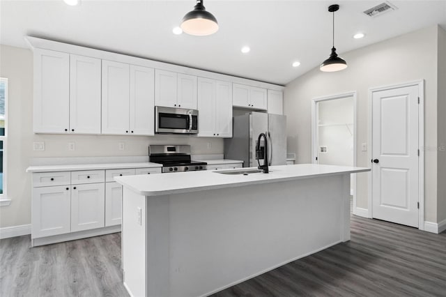 kitchen with stainless steel appliances, white cabinets, and pendant lighting