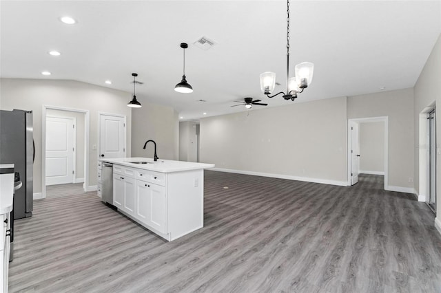 kitchen with sink, stainless steel appliances, white cabinetry, pendant lighting, and a kitchen island with sink