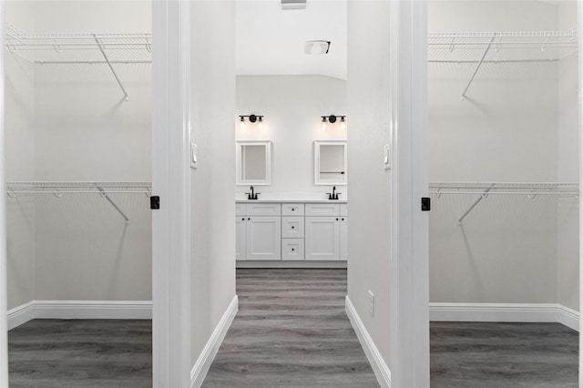 bathroom with vaulted ceiling, vanity, and wood-type flooring