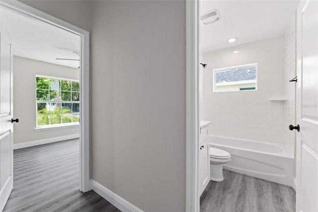 full bathroom featuring wood-type flooring, toilet, vanity, ceiling fan, and shower / bathing tub combination