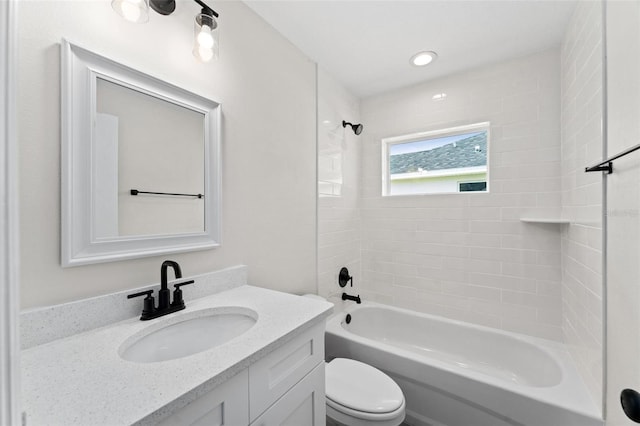 full bathroom featuring vanity, tiled shower / bath combo, and toilet