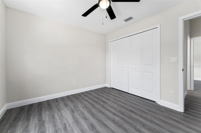 unfurnished bedroom with ceiling fan, a closet, and dark hardwood / wood-style floors