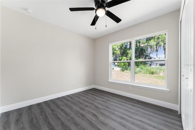 spare room with ceiling fan and dark wood-type flooring